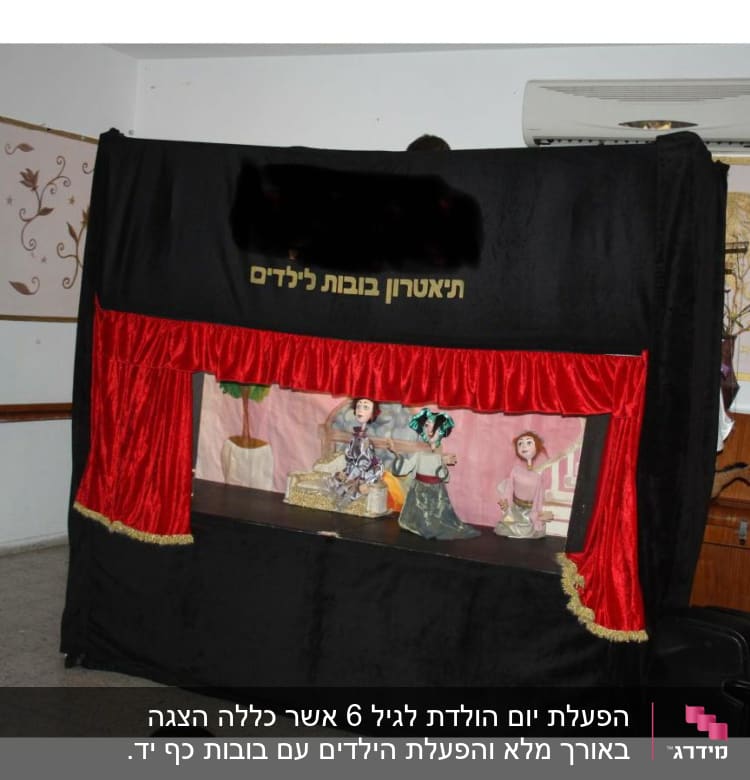 תיאטרון בובות עם וילון אדום ודמויות על במה